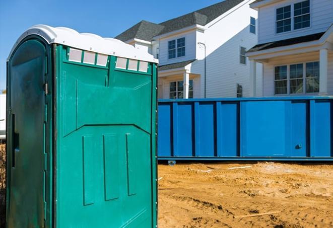 a row of porta potties on a bustling job site